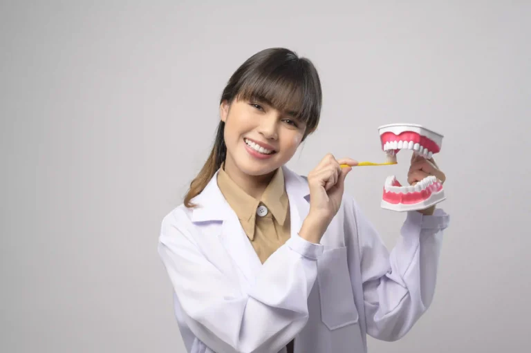 young-female-dentist-smiling-white-background-studio