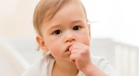 Bayi mengalami teething dengan menggigit jari sebagai respons gusi tidak nyaman